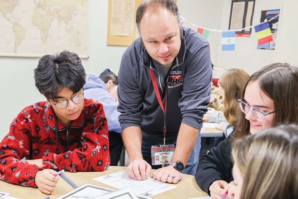 A teacher working with students at a classroom table