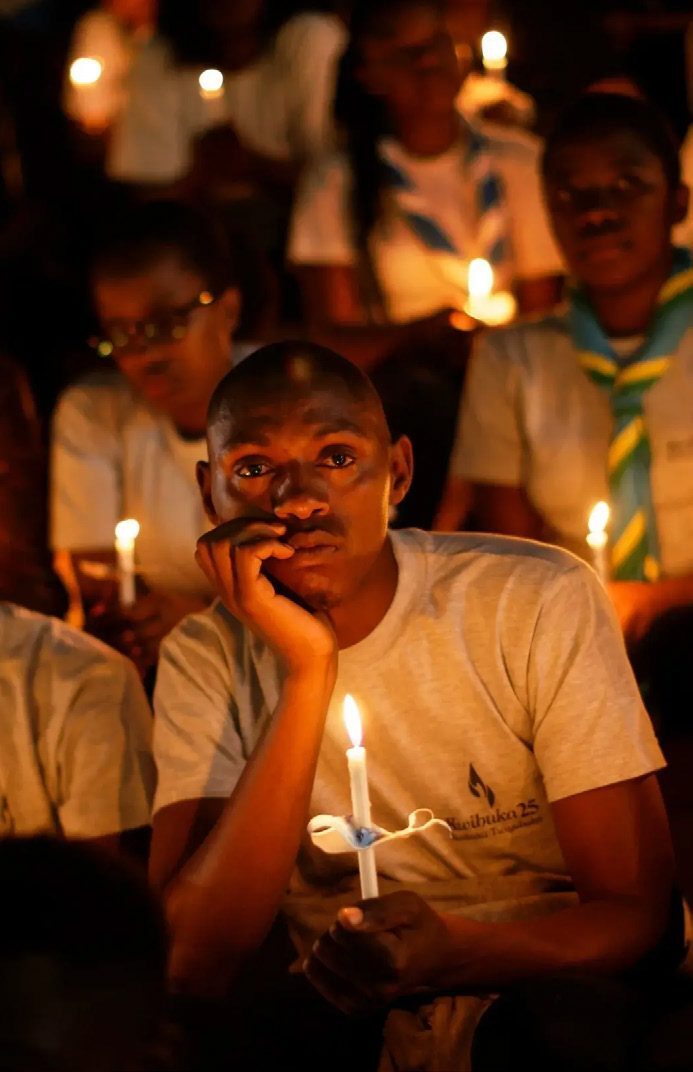 Rwandans sitting in the stands of Amahoro stadium hold candles as part of a candlelit vigil during a genocide memorial service, April 2019